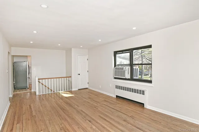 a view of a room with wooden floor and window