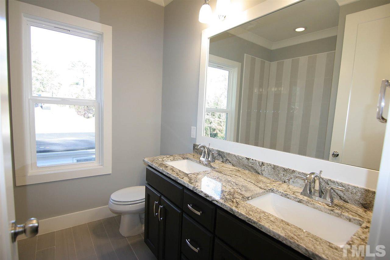 915 Marilyn Drive Raleigh, NC 27607 - Photo 23 of 25 a bathroom with a granite countertop sink a toilet and a window