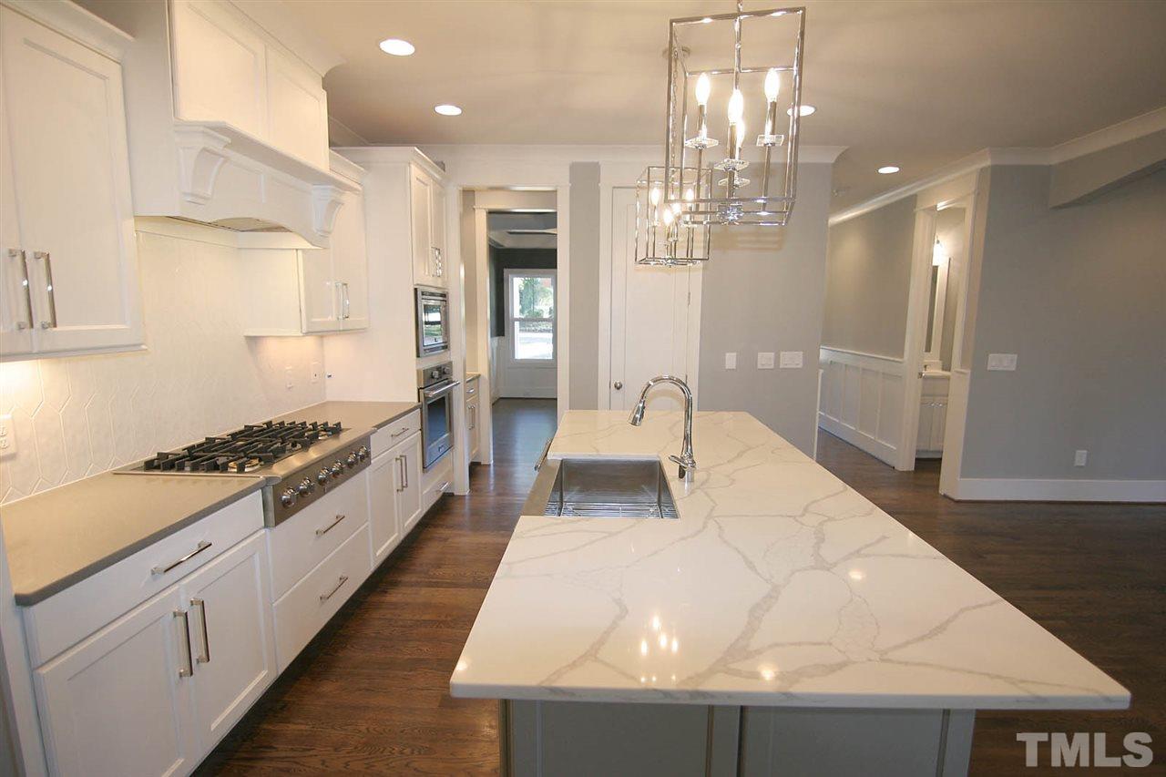 915 Marilyn Drive Raleigh, NC 27607 - Photo 9 of 25 a large white kitchen with stainless steel appliances