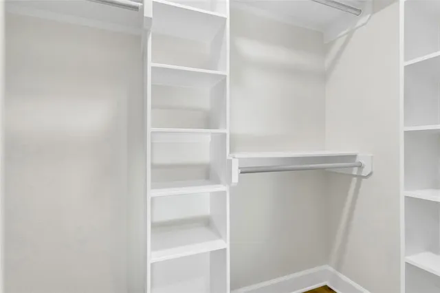 a view of walk in closet with empty racks