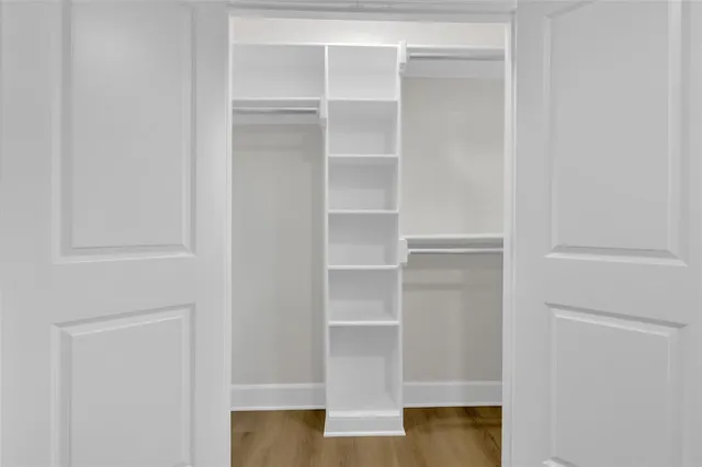 a view of walk in closet with empty racks