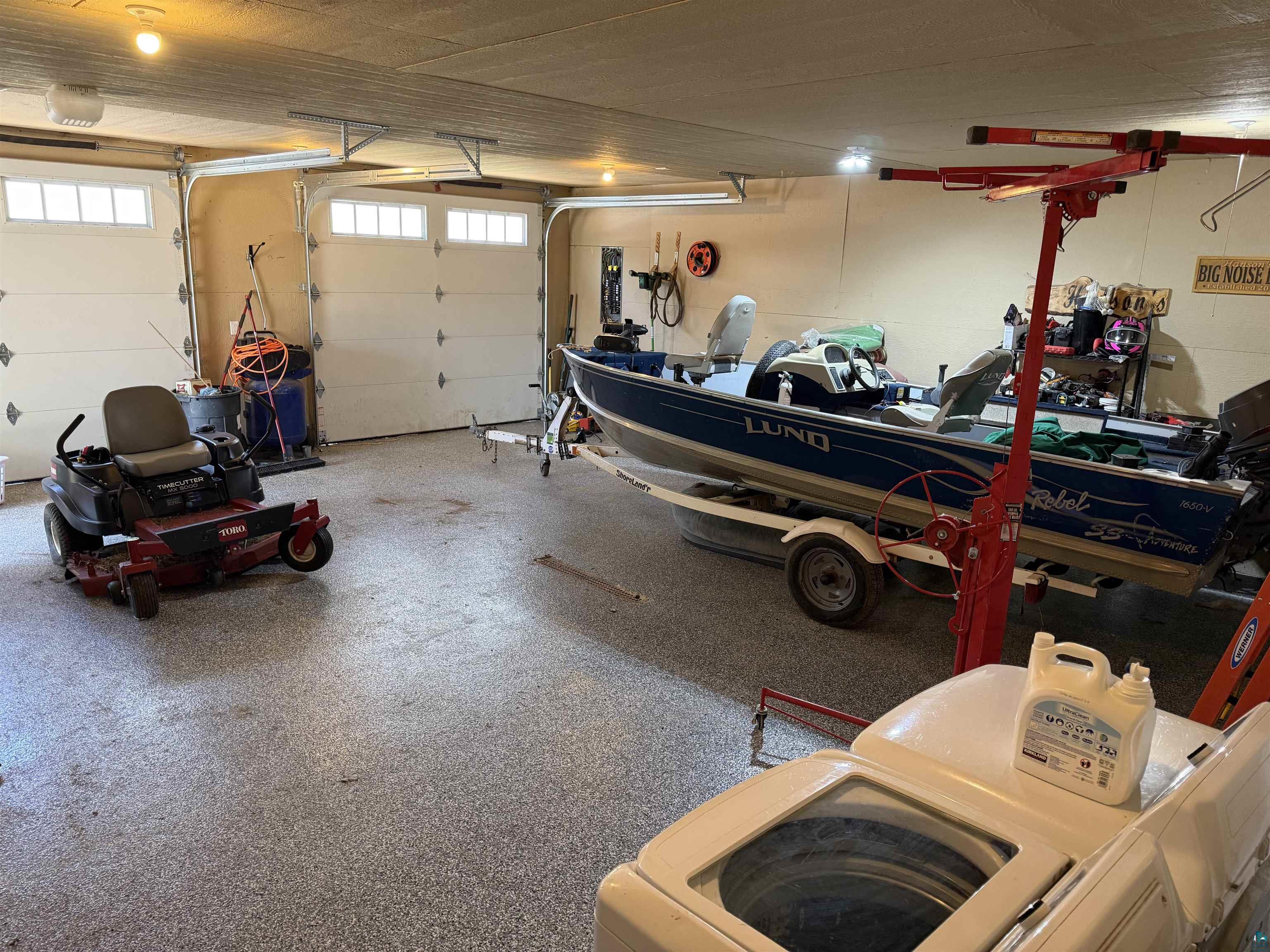 5274 Marble Lake Road Two Harbors, MN 55616 - Photo 51 of 79 Spacious garage with textured concrete flooring, two overhead garage doors featuring upper window panels, and interior lighting