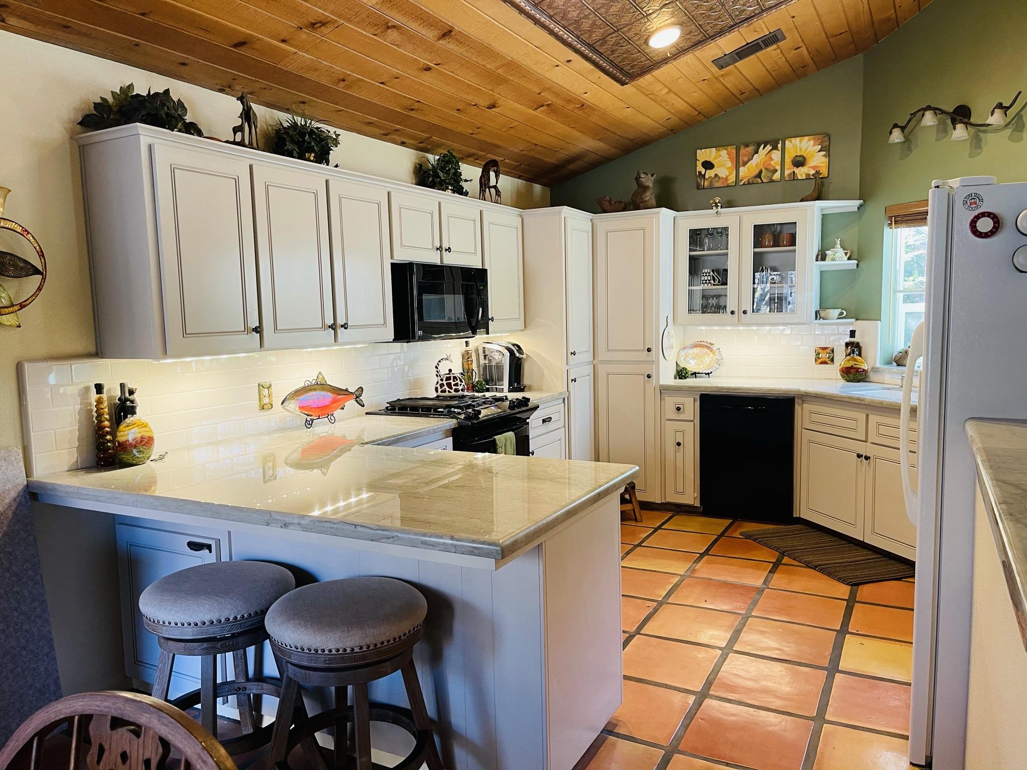 40964 Cherokee Oaks Drive Three Rivers, CA 93271 - Photo 6 of 41 a kitchen with a sink a stove and a refrigerator