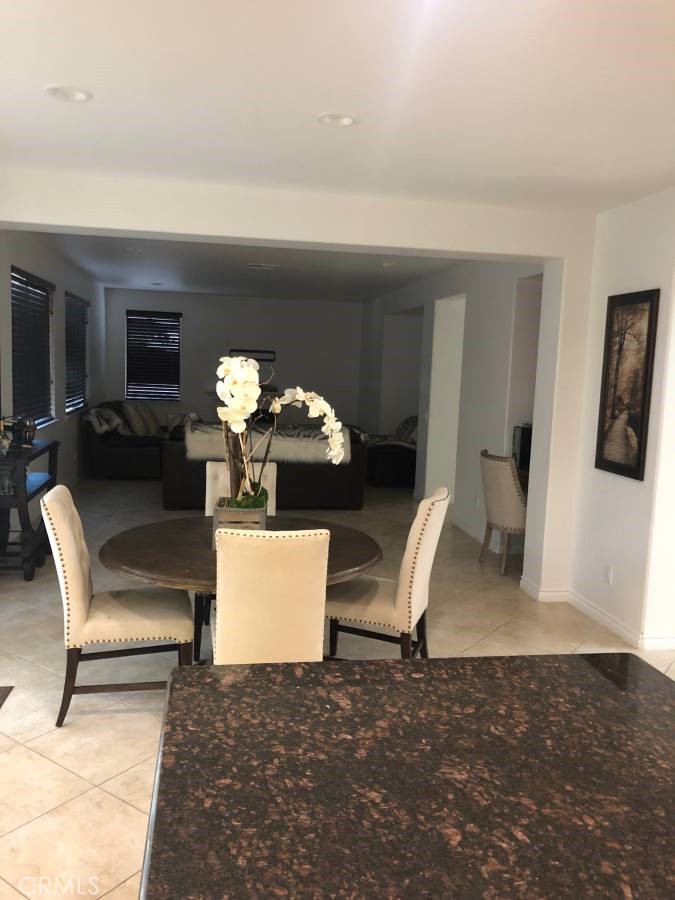 14653 Meadowsweet Drive Eastvale, CA 92880 - Photo 5 of 15 a living room with furniture a dining table and chairs