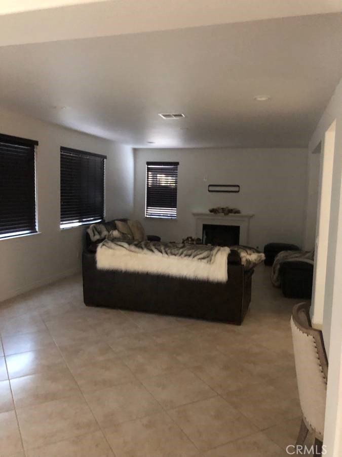 14653 Meadowsweet Drive Eastvale, CA 92880 - Photo 6 of 15 a spacious bedroom with a bed and a flat screen tv