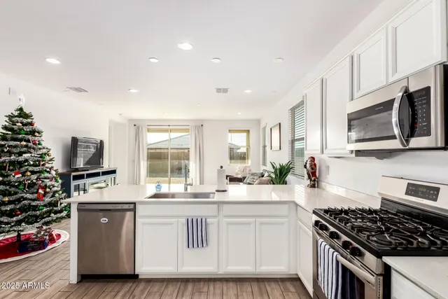 a kitchen with stainless steel appliances kitchen island granite countertop a stove a sink and a microwave
