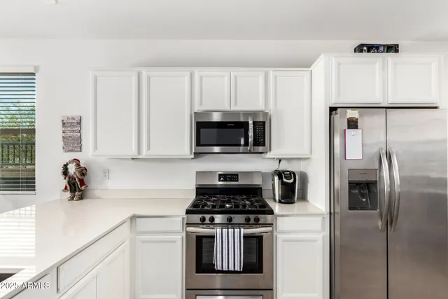 a kitchen with stainless steel appliances a stove a microwave and a refrigerator