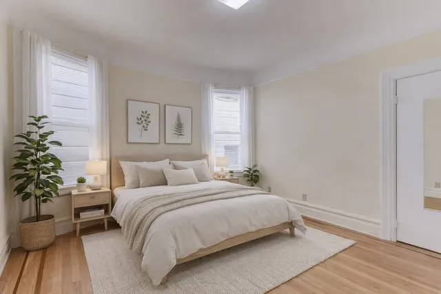 a bedroom with a large bed and a potted plant