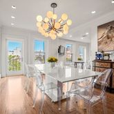 a view of a dining room with furniture a chandelier and wooden floor