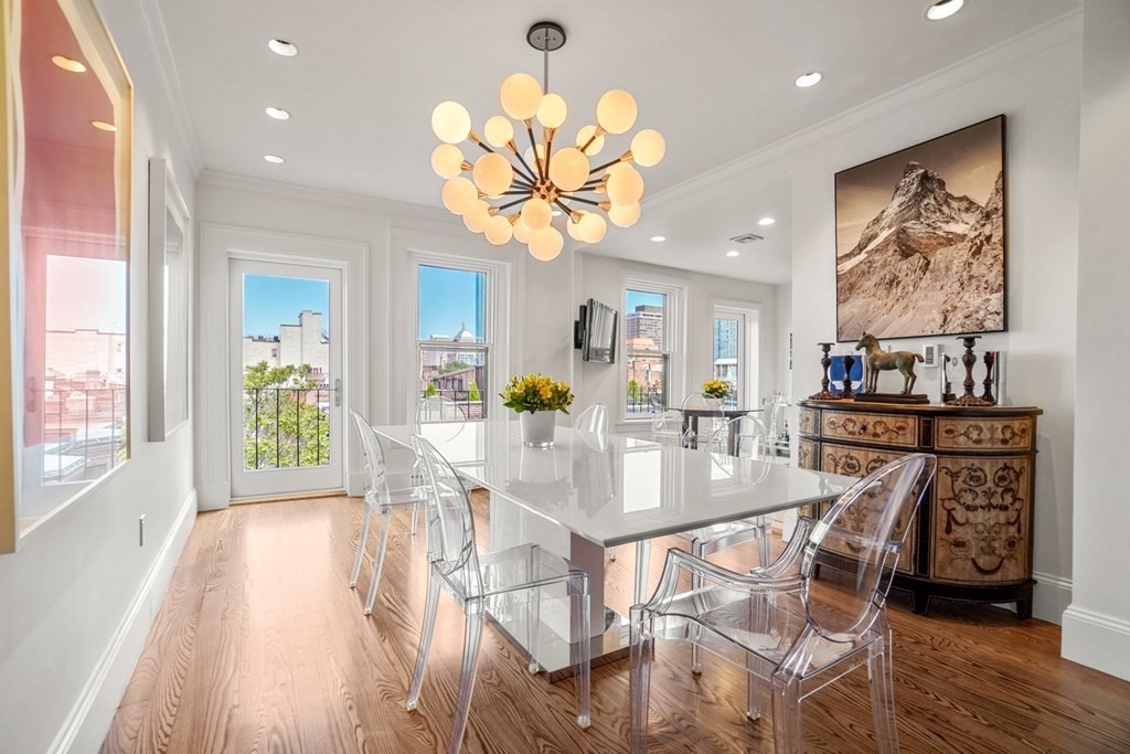a view of a dining room with furniture a chandelier and wooden floor