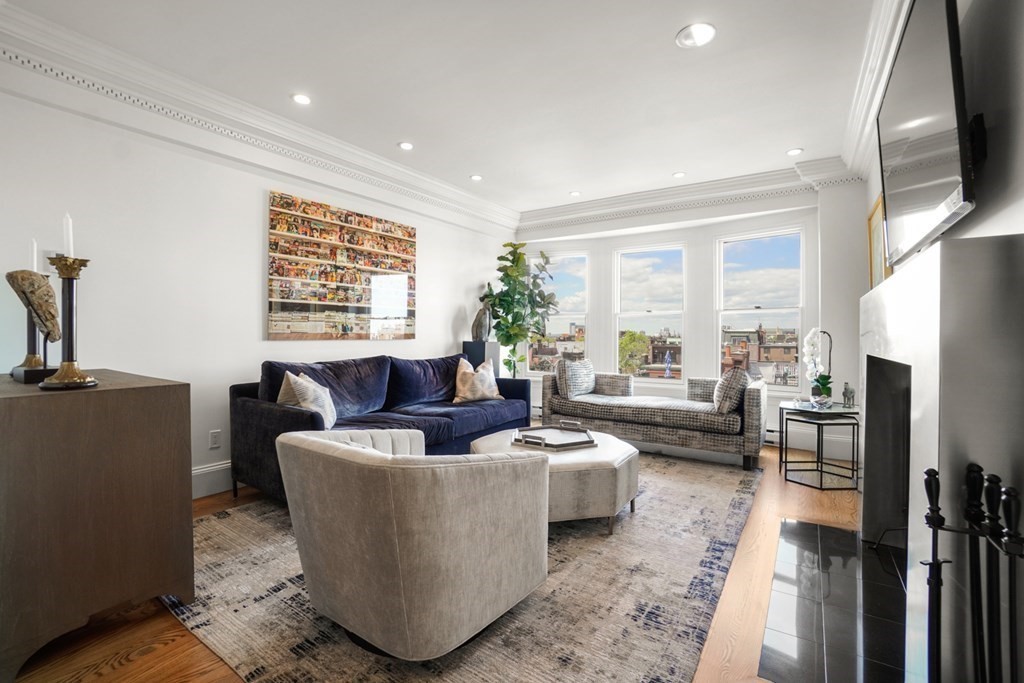 333 Commonwealth Avenue, Unit PH22 Boston, MA 02115 - Photo 12 of 42 a living room with fireplace furniture and a large window