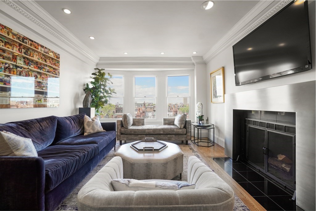 333 Commonwealth Avenue, Unit PH22 Boston, MA 02115 - Photo 13 of 42 a living room with furniture a flat screen tv and a fireplace