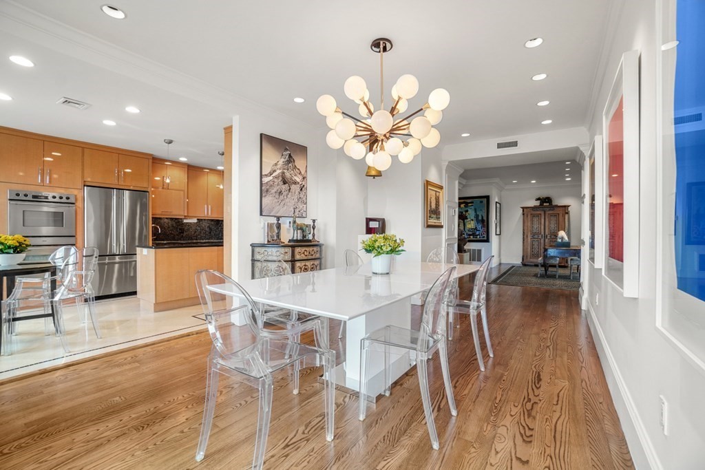 333 Commonwealth Avenue, Unit PH22 Boston, MA 02115 - Photo 3 of 42 a view of a dining hall with a dining table chairs and couches with wooden floor