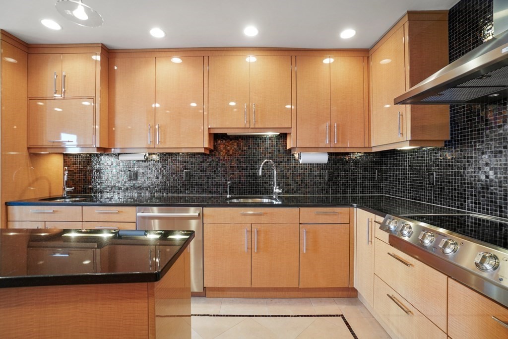 333 Commonwealth Avenue, Unit PH22 Boston, MA 02115 - Photo 6 of 42 a kitchen with kitchen island granite countertop a sink a stove and cabinets