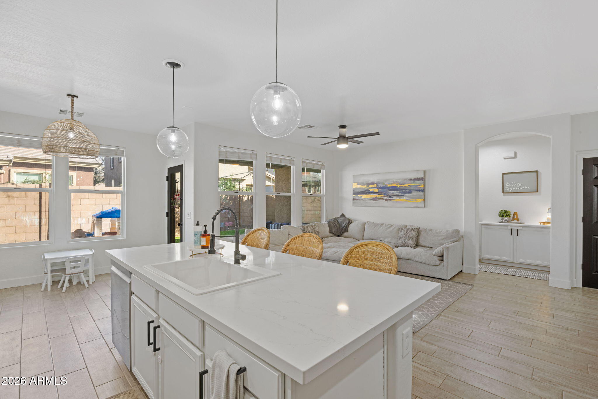 3458 East Robin Lane Gilbert, AZ 85296 - Photo 11 of 32 a large white kitchen with a large island oven a stove a sink a dining table and chairs