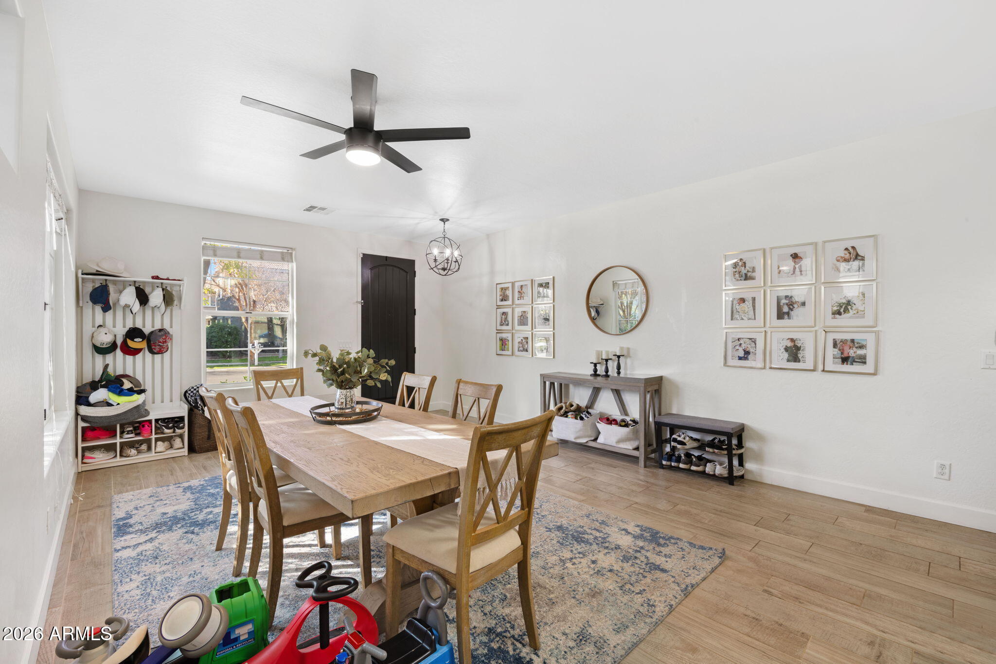 3458 East Robin Lane Gilbert, AZ 85296 - Photo 6 of 32 a dining room with wooden floor a chandelier a wooden table and chairs