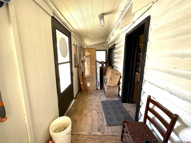 a view of a hallway with furniture and wooden floor