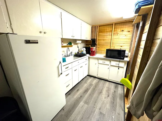 a kitchen with stainless steel appliances a refrigerator a sink a stove top oven a counter space and cabinets