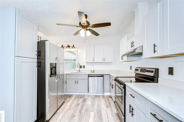 a kitchen with cabinets a sink and appliances