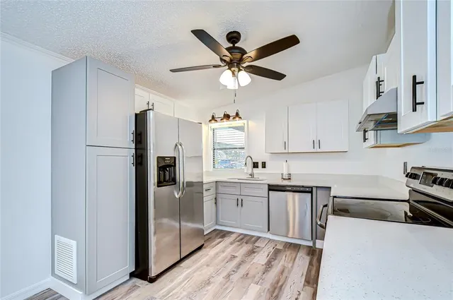 a kitchen with stainless steel appliances a refrigerator sink and cabinets