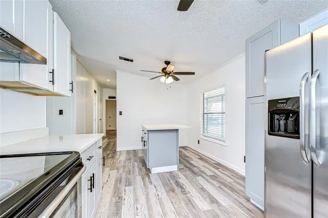 a kitchen view with wooden floor electronic appliances and window