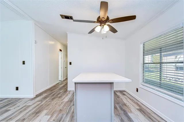 a view of a hallway with a ceiling fan and a window