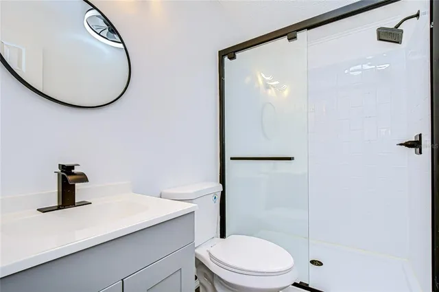 a bathroom with a toilet a sink and mirror