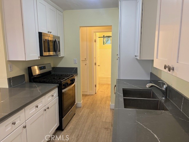 996 North Crescent Avenue San Bernardino, CA 92410 - Photo 6 of 10 a kitchen with granite countertop a sink stove and cabinets