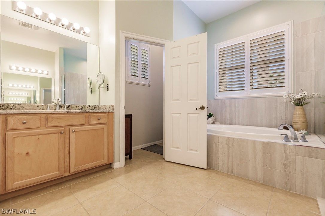 12901 Timber Ridge Drive Fort Myers, FL 33913 - Photo 26 of 49 a spacious bathroom with a double vanity sink a mirror and a bathtub