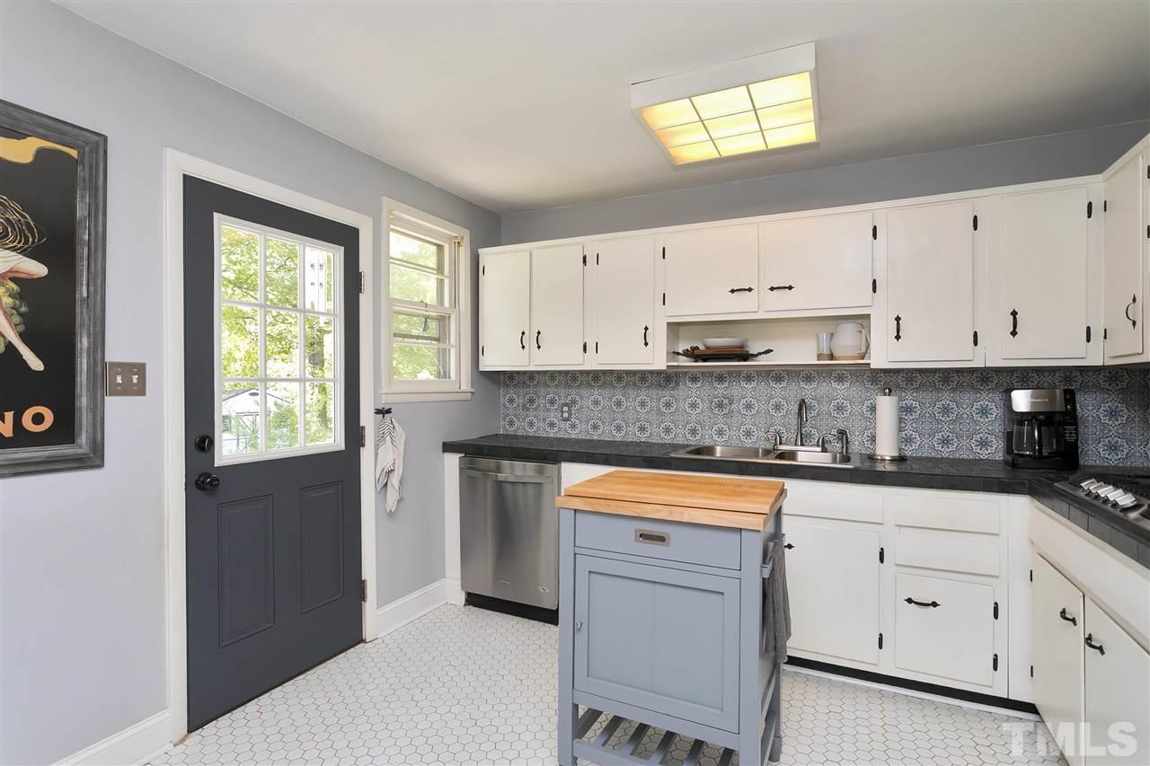 3417 Apache Drive Raleigh, NC 27609 - Photo 5 of 25 a kitchen with granite countertop white cabinets and white appliances