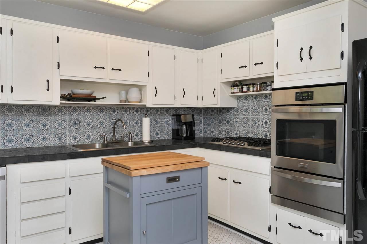 3417 Apache Drive Raleigh, NC 27609 - Photo 7 of 25 a kitchen with granite countertop white cabinets and stainless steel appliances
