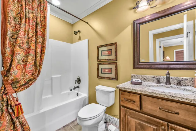a bathroom with a granite countertop sink mirror vanity and toilet