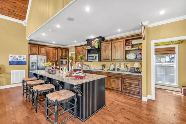 a kitchen with stainless steel appliances kitchen island granite countertop a sink and cabinets