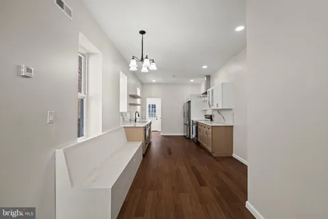 a view of a kitchen with a sink and wooden floor