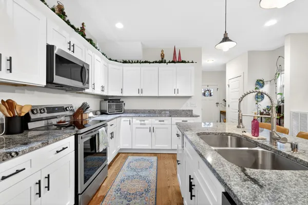 a kitchen with stainless steel appliances granite countertop a sink and a stove