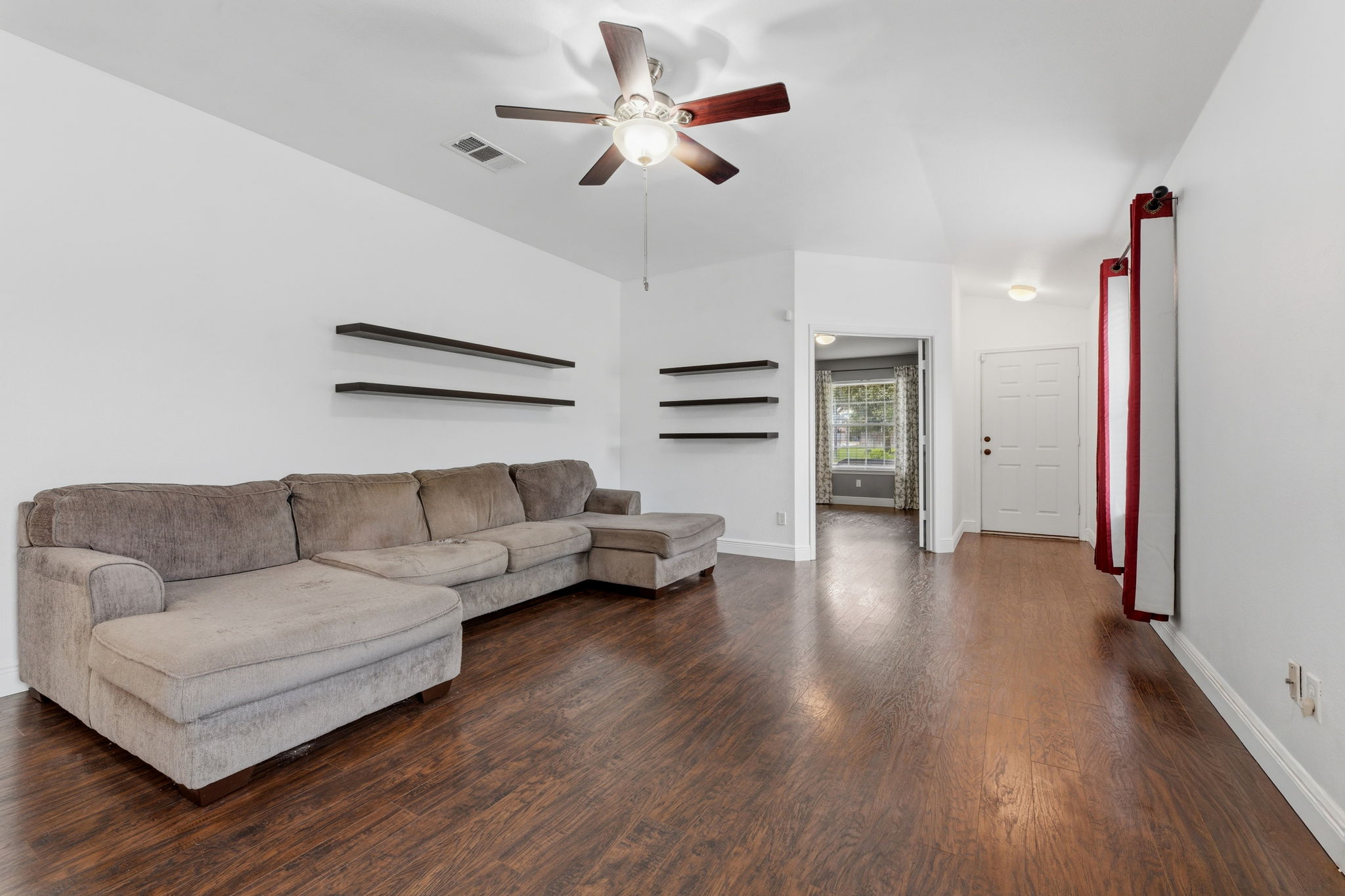 12601 Waynespur Lane Elgin, TX 78621 - Photo 11 of 38 A welcoming living room featuring richly toned wood flooring and a refreshing ceiling fan.