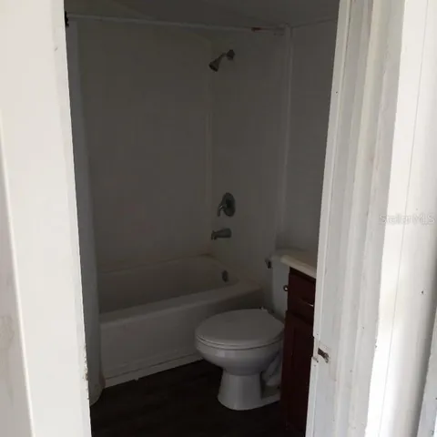 a white toilet sitting next to a bath tub