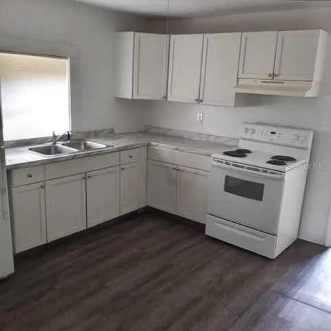 a kitchen with granite countertop white cabinets and white appliances