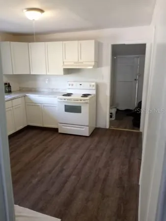 a kitchen with granite countertop white cabinets and white appliances