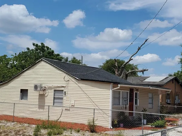 a view of a white house next to a yard