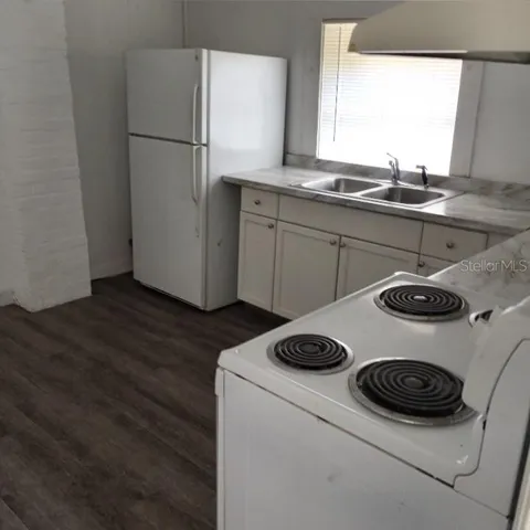 a kitchen with a stove a refrigerator and a sink