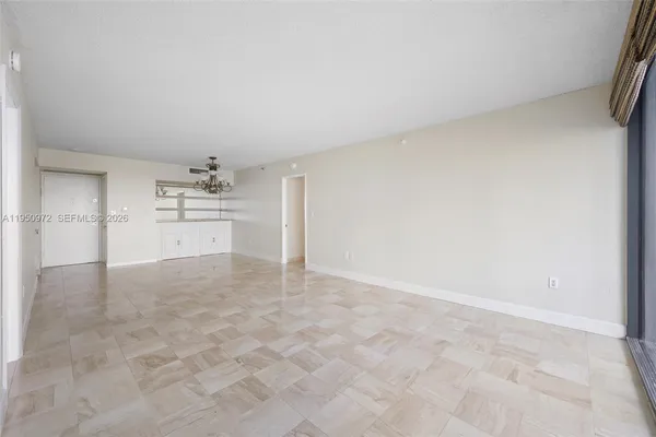 a view of empty room with a kitchen