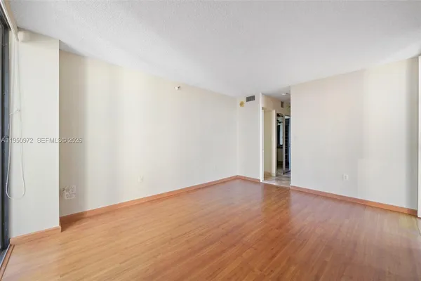 a view of an empty room with wooden floor