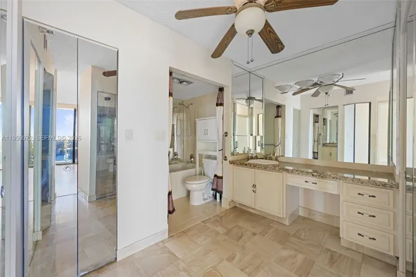 a large bathroom with a granite countertop sink mirror and a bathtub