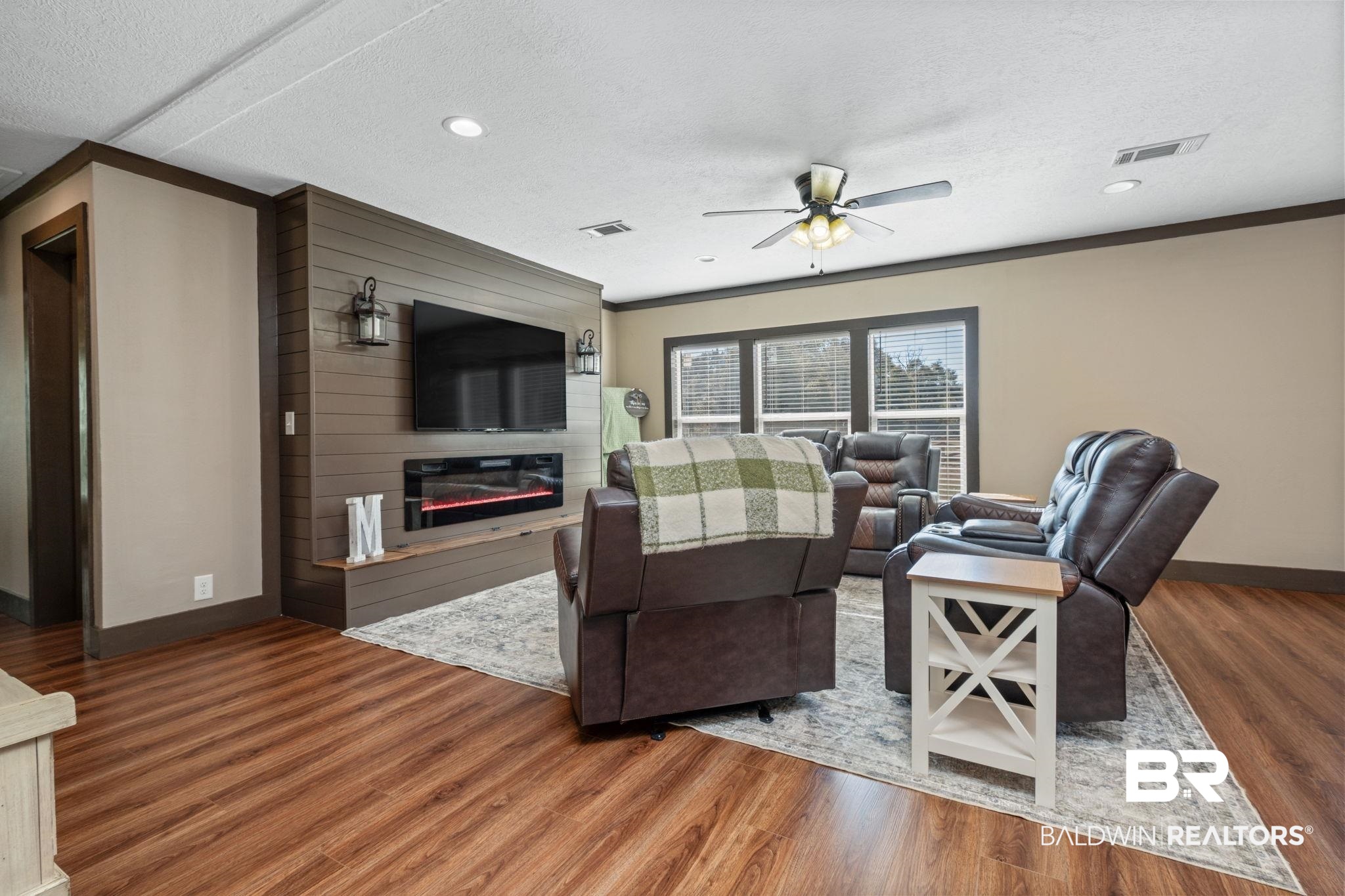 15080 Starlight Avenue Wilmer, AL 36587 - Photo 9 of 29 Living room with crown molding, a textured ceiling, ceiling fan, a fireplace, and hardwood / wood-style floors