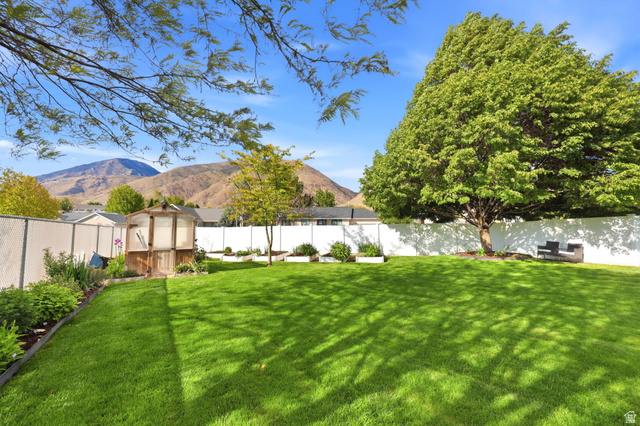 1816 River Bottom Road Springville, UT 84663 - Photo 30 of 37 Expansive rear yard featuring a verdant lawn, mature shade trees, and a functional greenhouse structure
