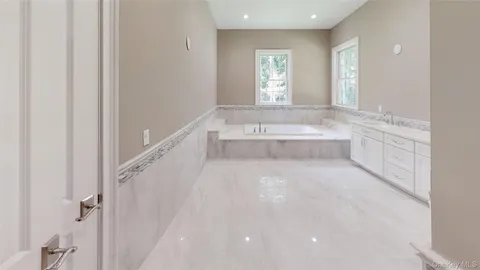 a bathroom with a tub sink and mirror
