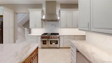 a kitchen with a stove and white cabinets