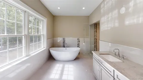 a bathroom with a granite countertop sink and a large mirror