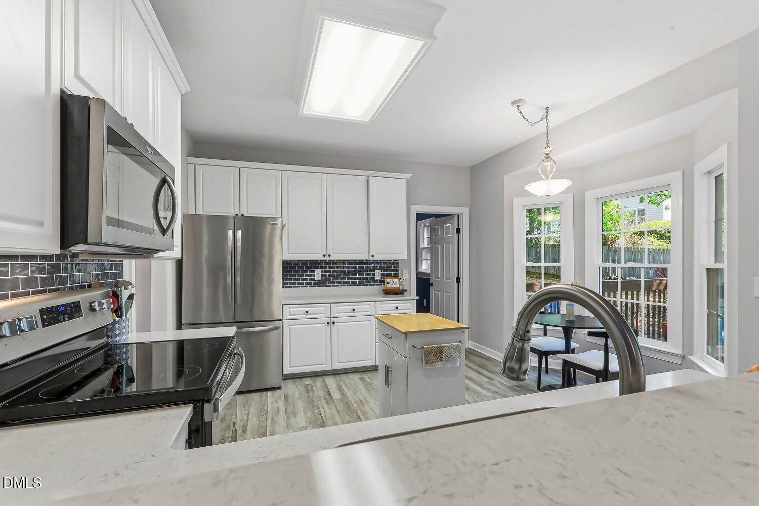 4001 Batiste Road Raleigh, NC 27613 - Photo 15 of 63 a kitchen with a refrigerator a stove a sink and a stove next to a window